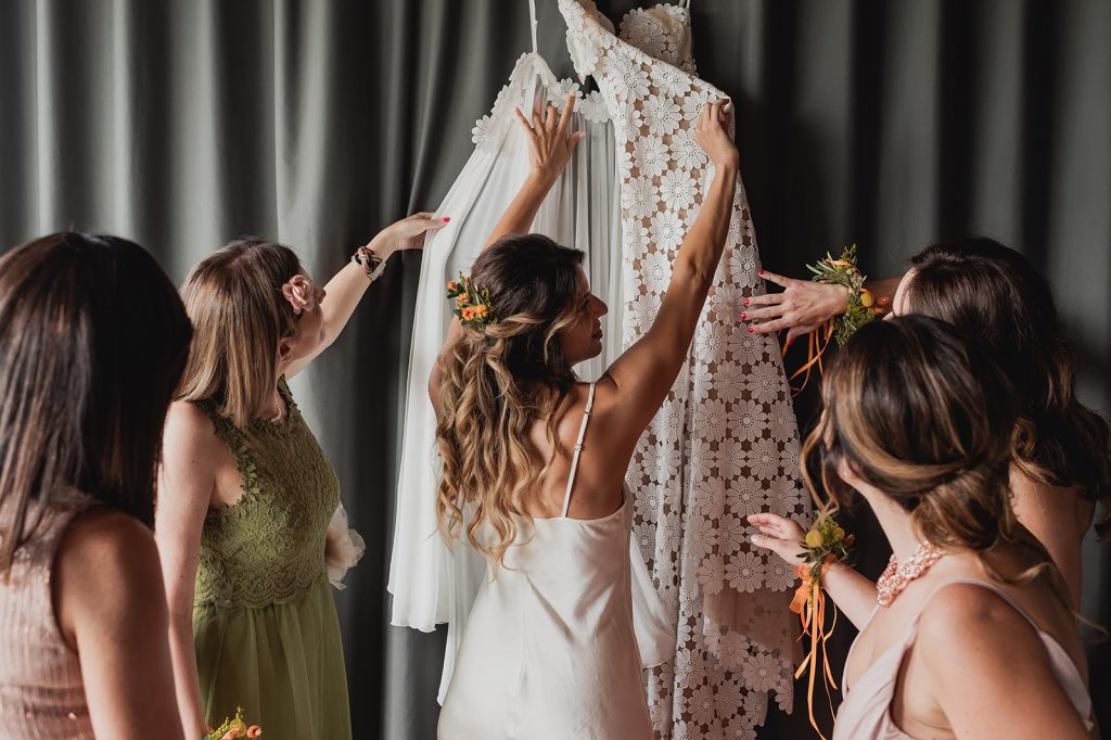 the-bride-dresses-with-the-help-of-the-bridesmaids